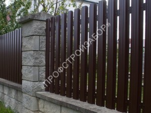 Забор из металлического штакетника на каменных столбах